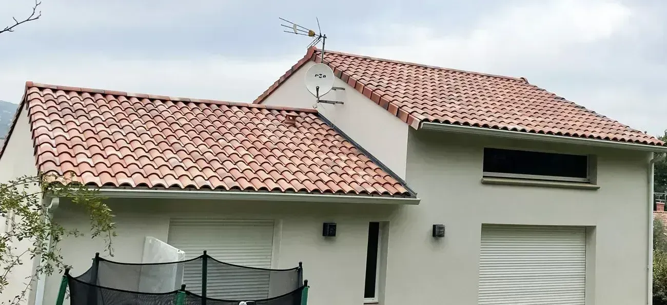 Maison au toit de tuiles propres, petit balcon et grandes fenêtres, après un démoussage