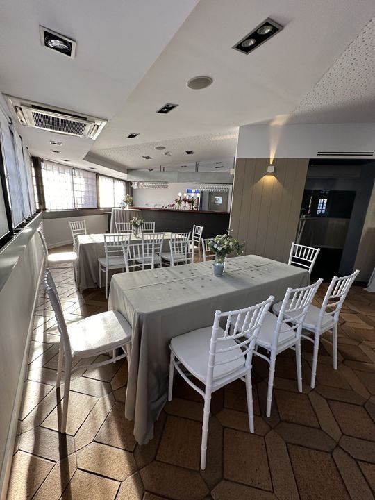 Un comedor con mesas y sillas y un gran ventanal.