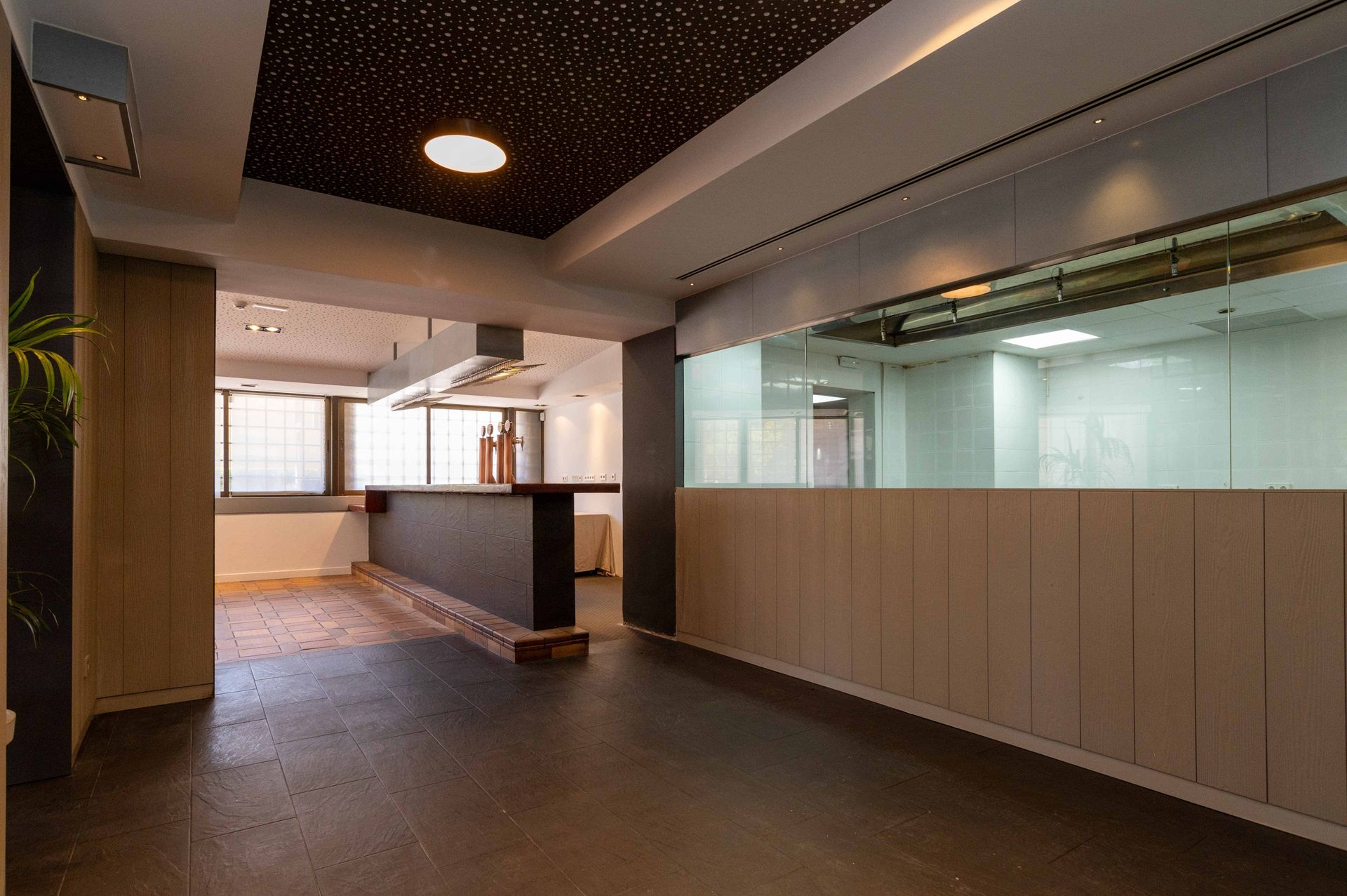Una gran habitación vacía con un mostrador y muchas ventanas.
