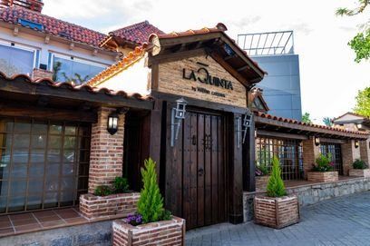 Un edificio de ladrillo con una puerta de madera y jardineras delante.
