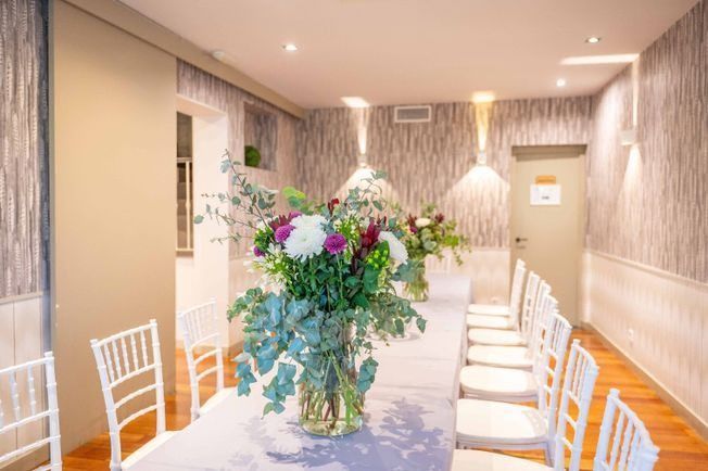 Hay un jarrón con flores en la mesa en el medio de la habitación.