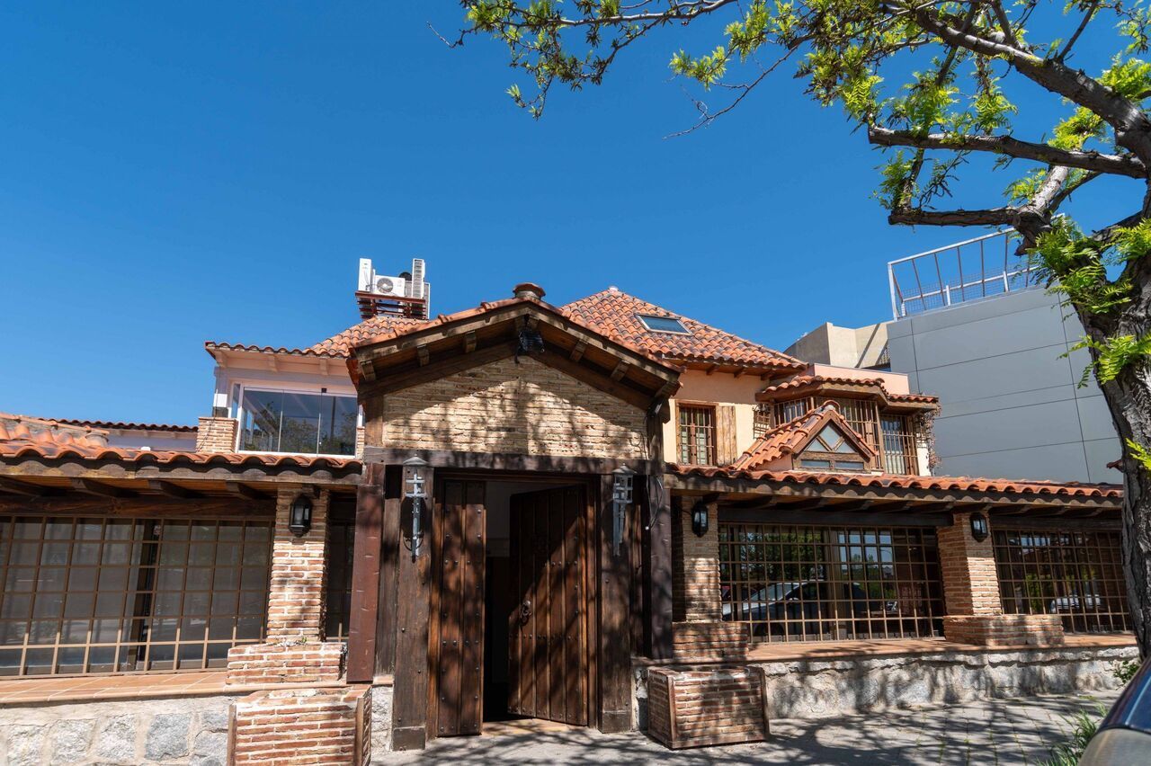 Una casa con techo de tejas rojas y una puerta de madera