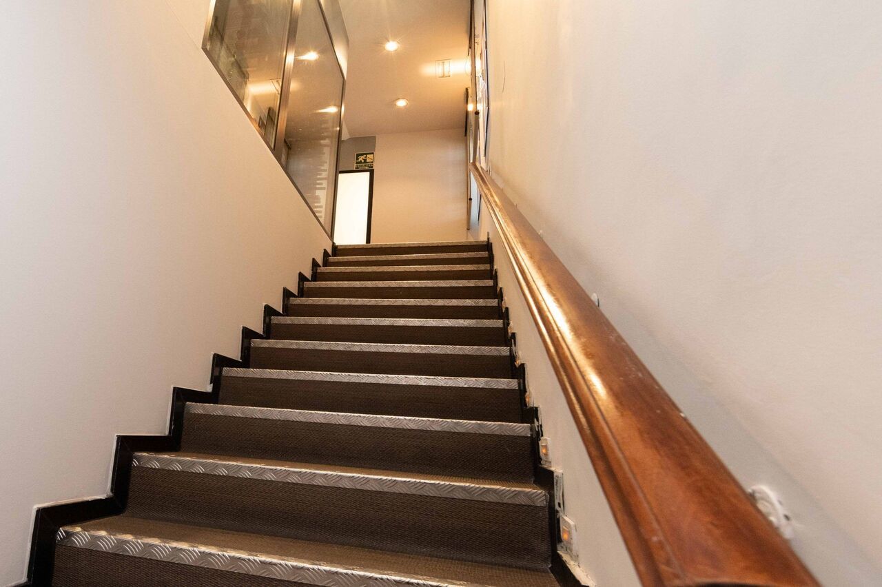 Un conjunto de escaleras con barandilla de madera y suelo alfombrado.