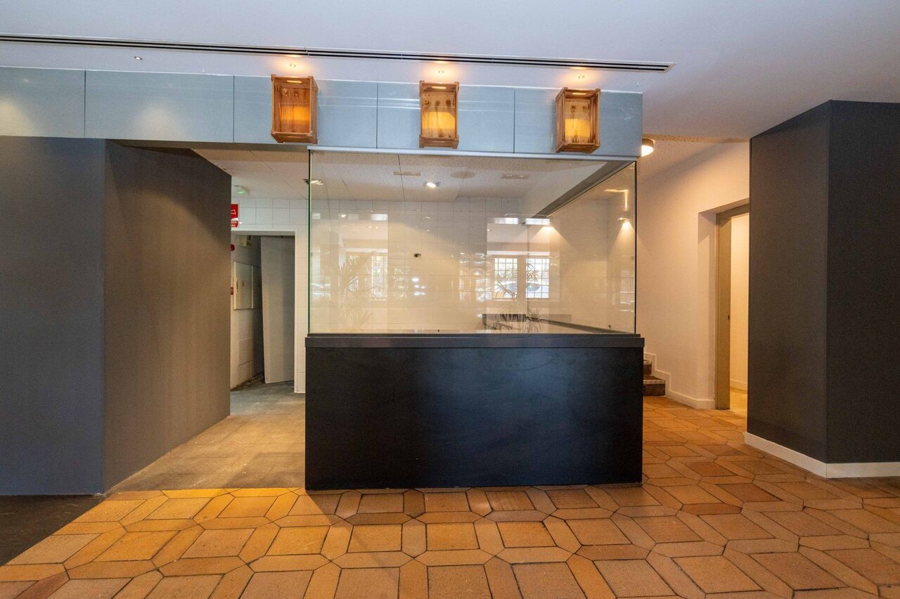 Una gran habitación vacía con un mostrador negro en el medio.