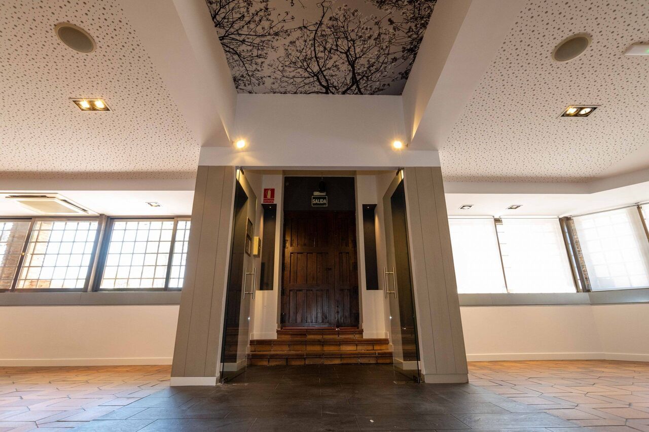 Una gran habitación vacía con un techo que tiene una imagen de un árbol.