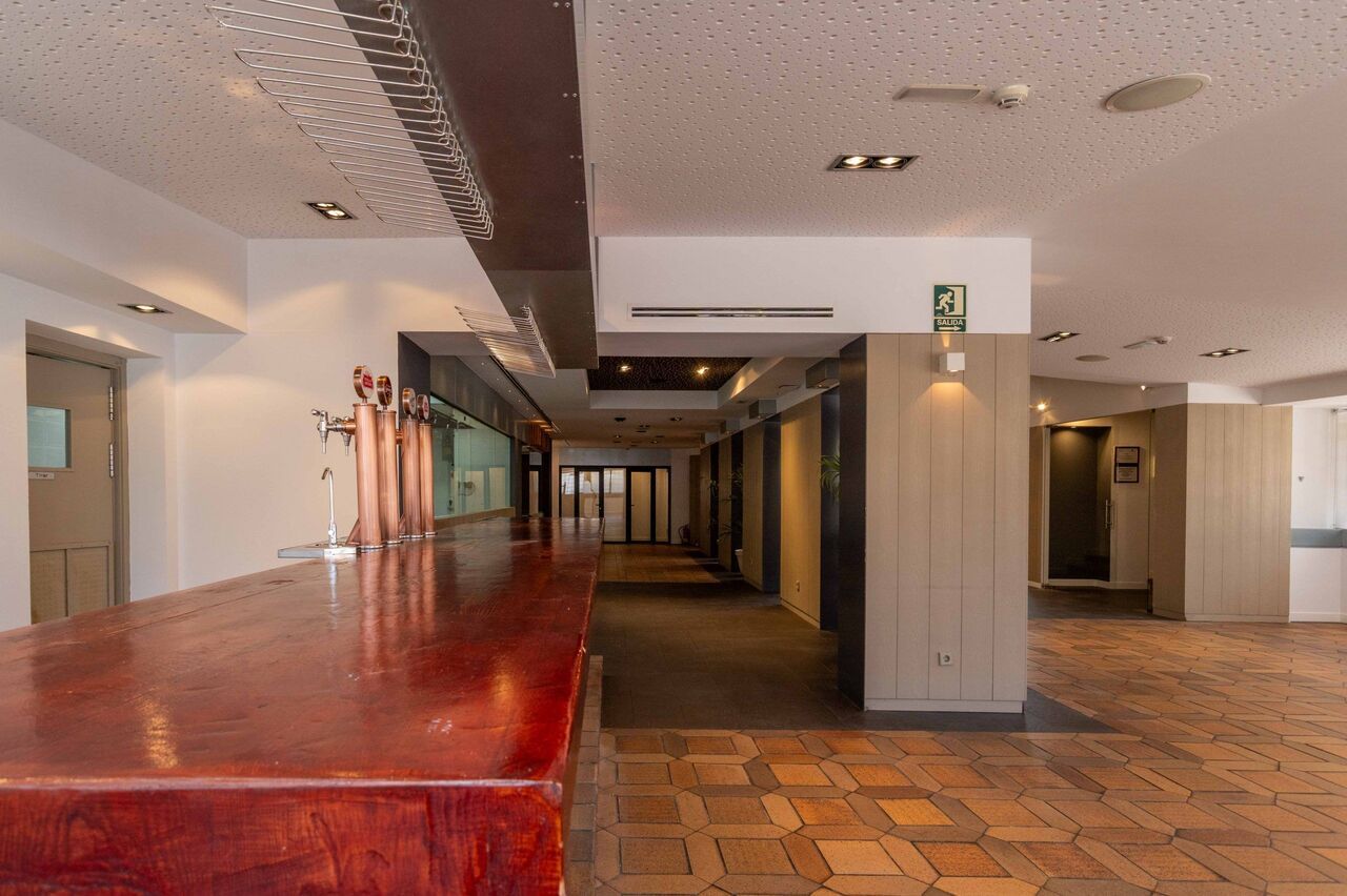 Un pasillo largo y vacío con una barra roja en el medio.