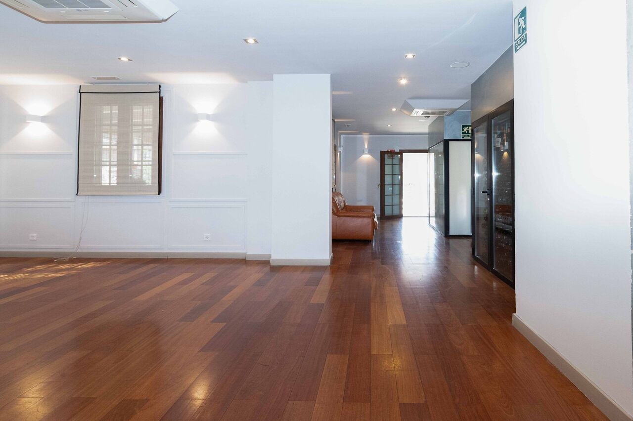 Una habitación vacía con pisos de madera y paredes blancas.