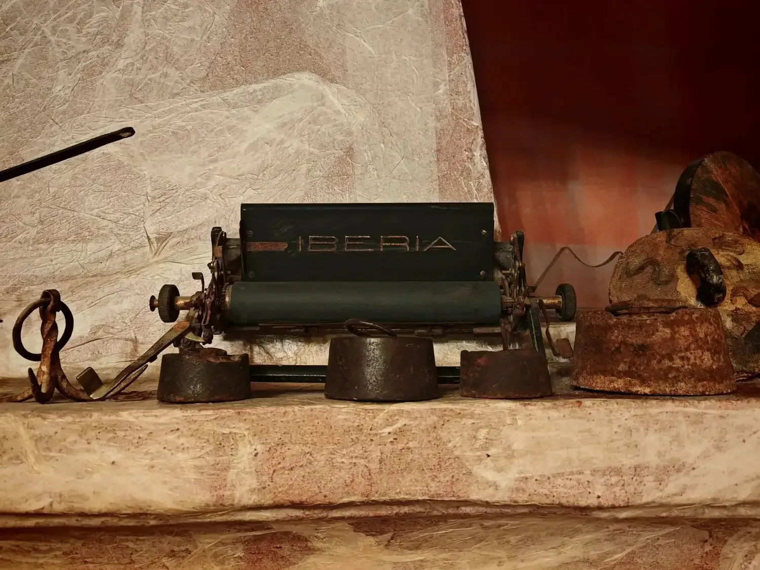 Comedor con mesa redonda preparada para invitados, sillas blancas, arte de pared colorido y entrada arqueada.