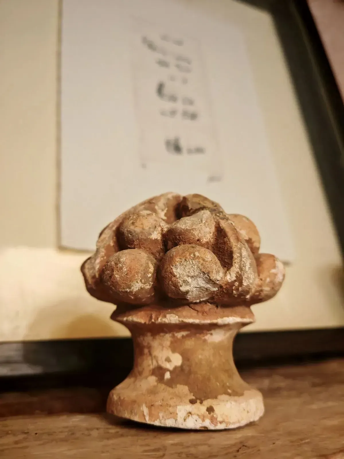 Comedor con mesa redonda preparada para invitados, sillas blancas, arte de pared colorido y entrada arqueada.