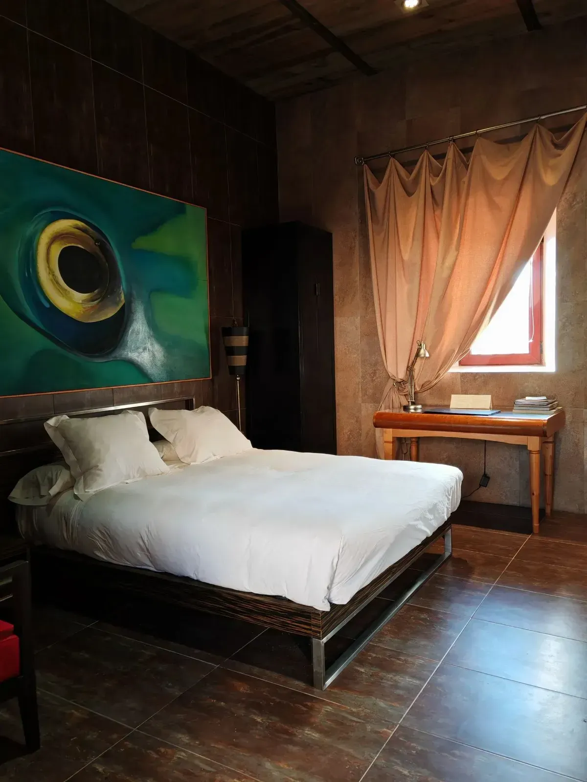 Dormitorio con dos camas individuales, paredes de madera en varios colores y lámpara de araña.