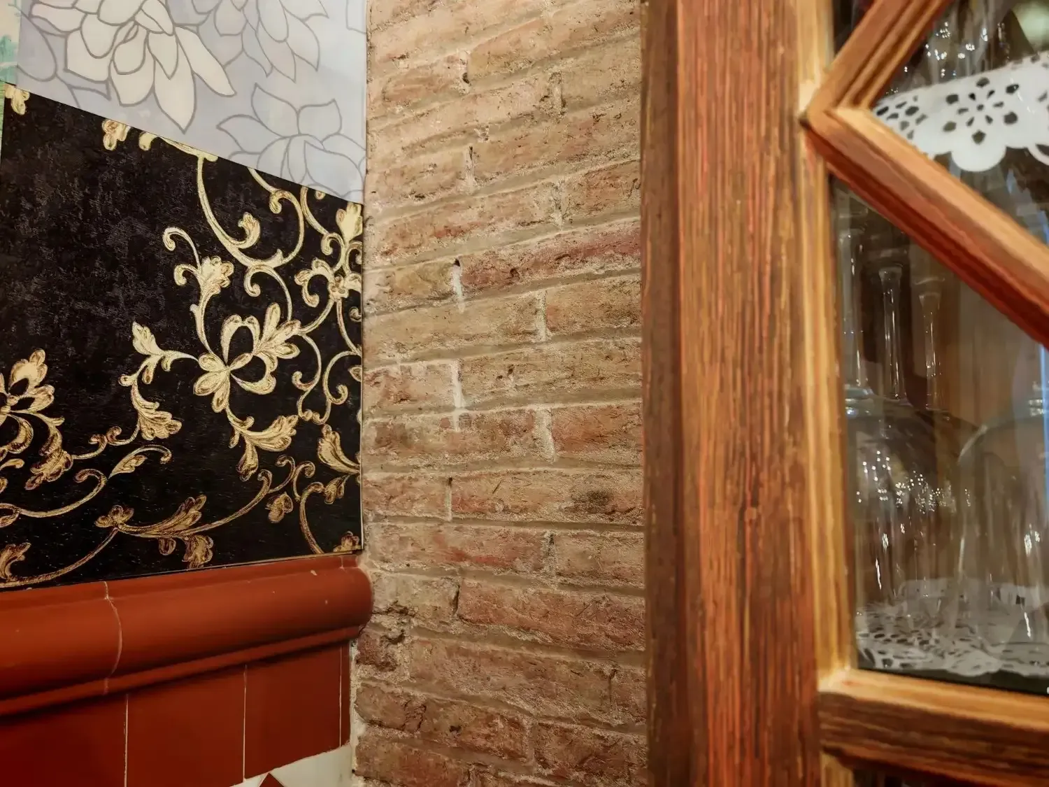 Comedor con mesa redonda preparada para invitados, sillas blancas, arte de pared colorido y entrada arqueada.