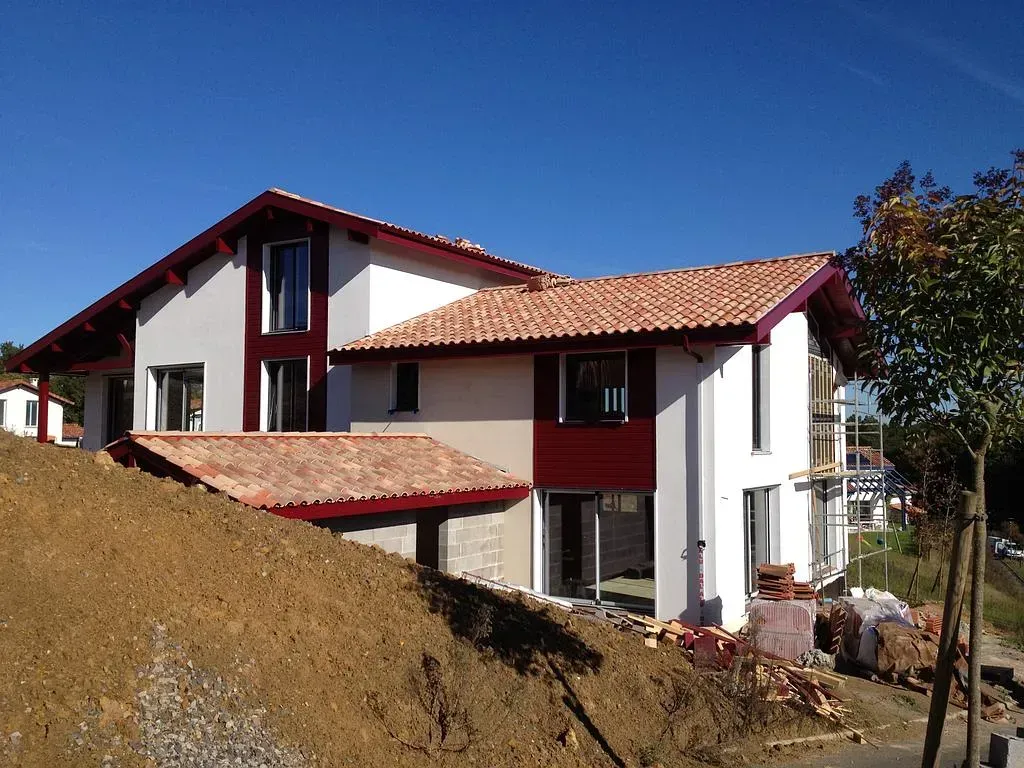 Maison rouge derrière une colline