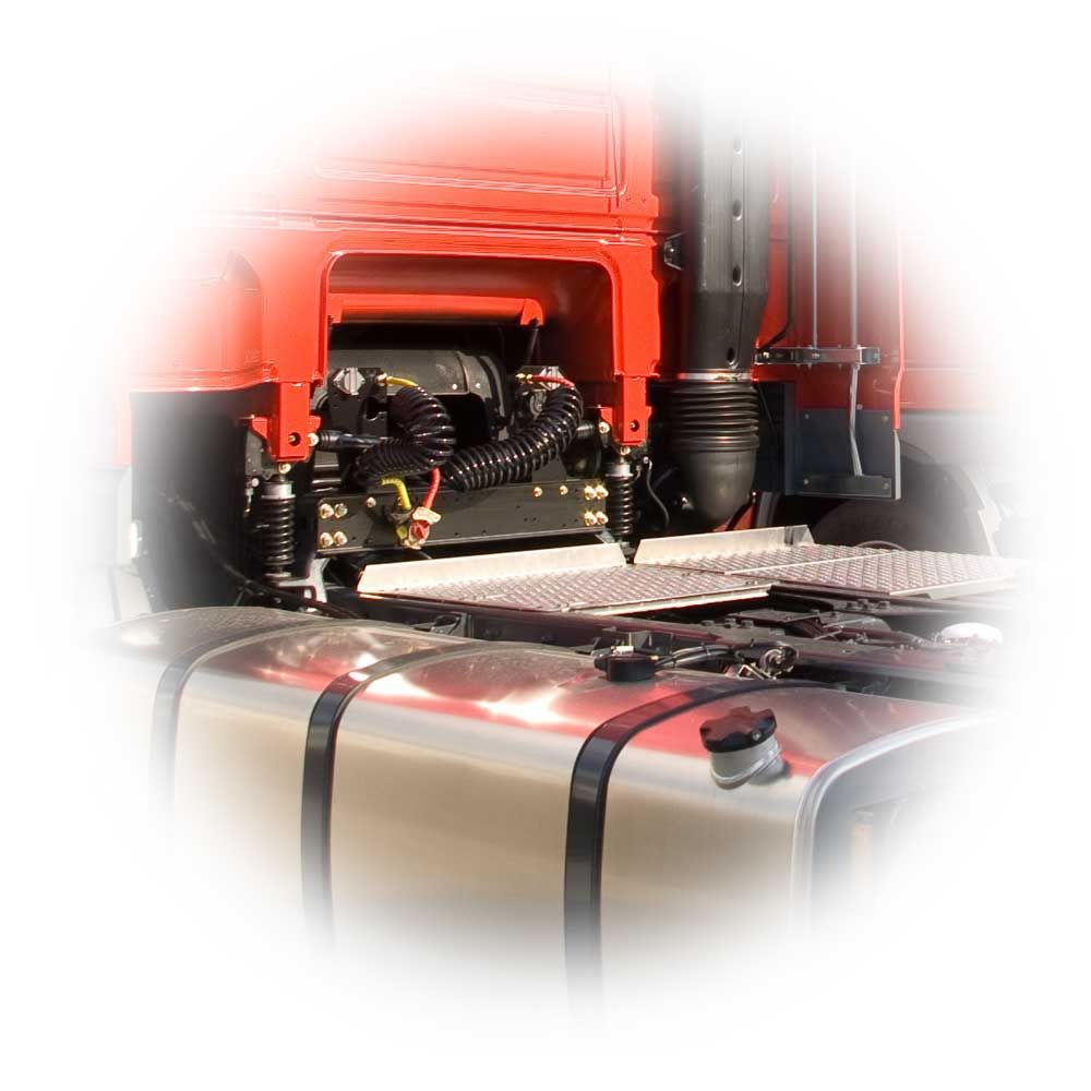 Cabine d'un semi-remorque rouge avec moteur et réservoir de carburant apparents, vue de profil en gros plan.