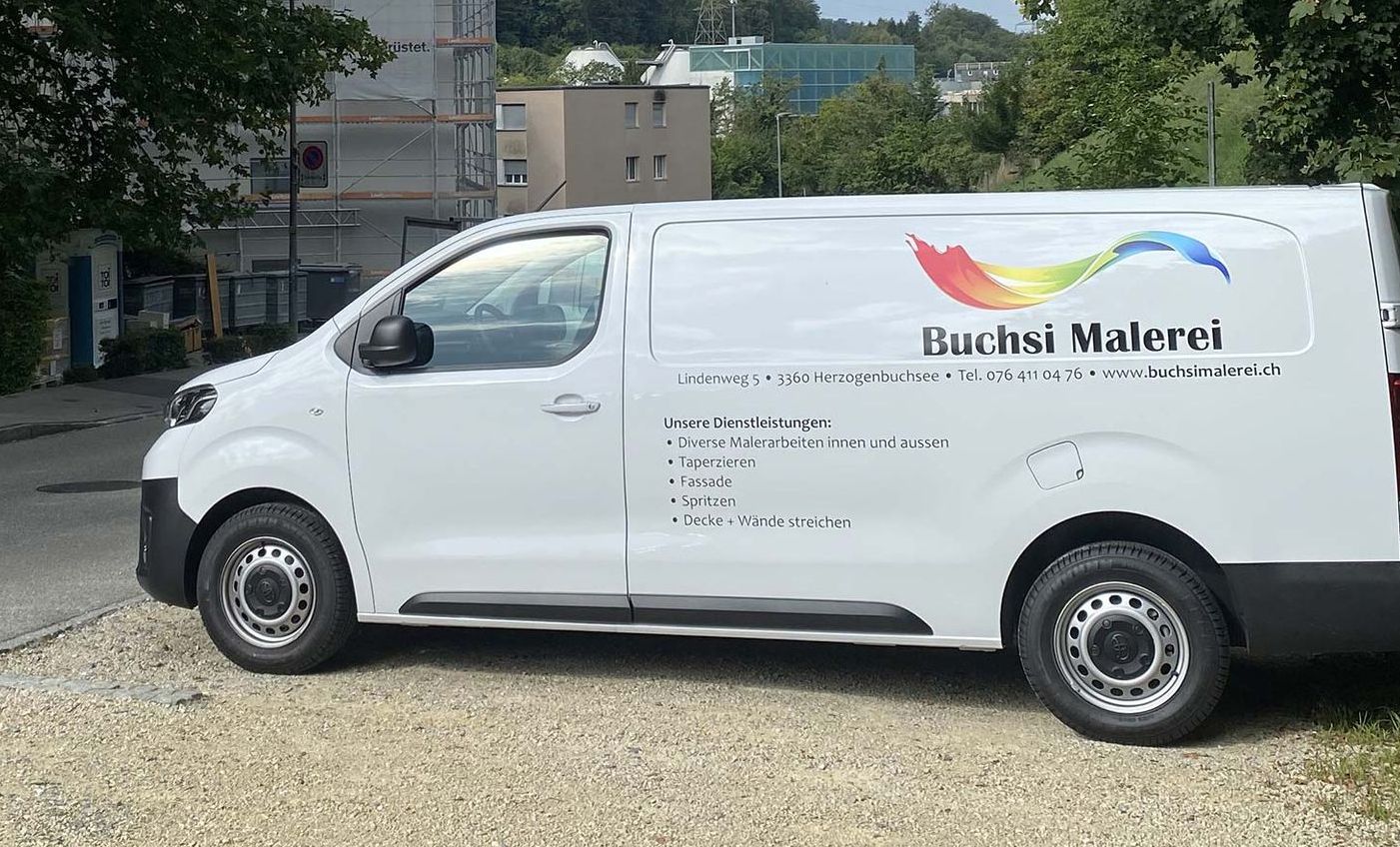 Ein weißer Lieferwagen steht am Straßenrand.