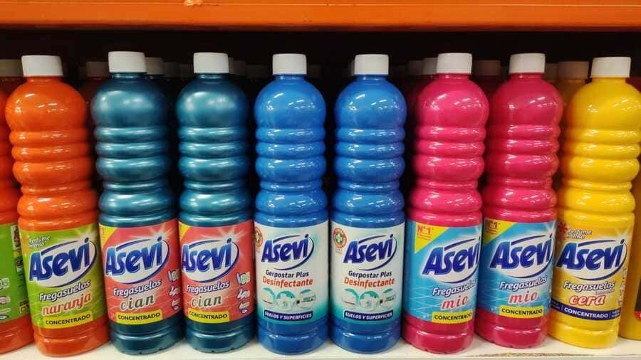 Una fila de productos de limpieza Asevi están alineados en un estante.