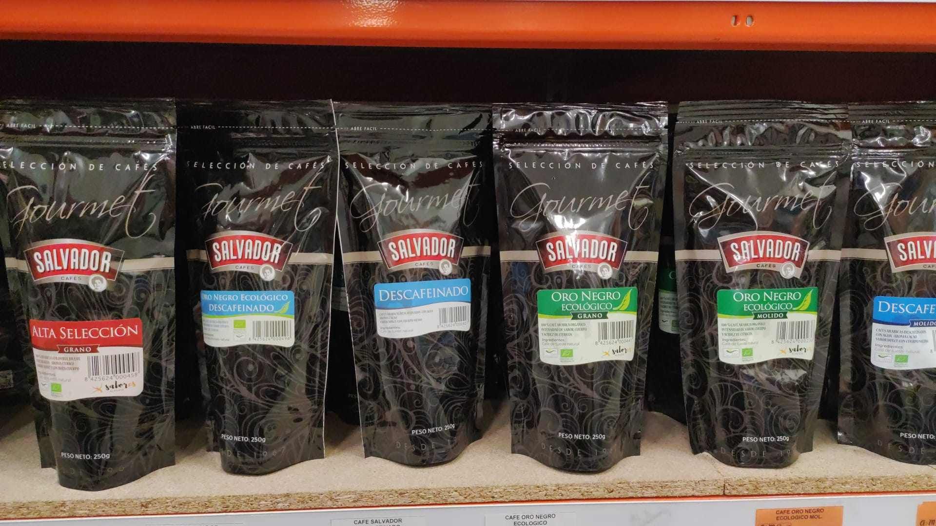 Un estante lleno de bolsas de granos de café en una tienda.