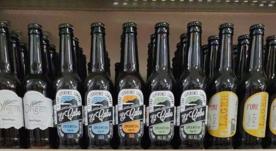 Varias botellas de cerveza están alineadas en un estante
