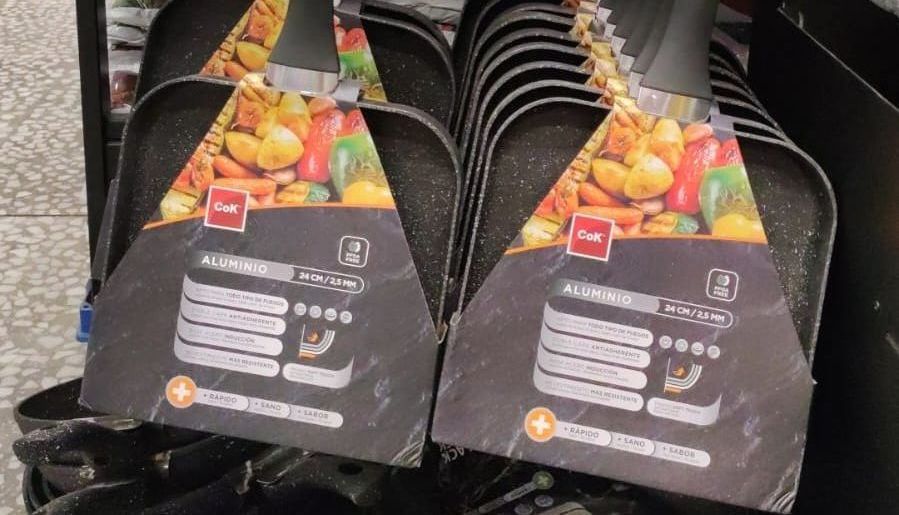 Una pila de sartenes colocadas una encima de otra en un estante de una tienda.