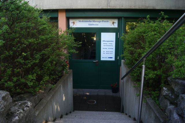 Treppe führt hinauf zu einer grünen Tür mit einem Schild darauf