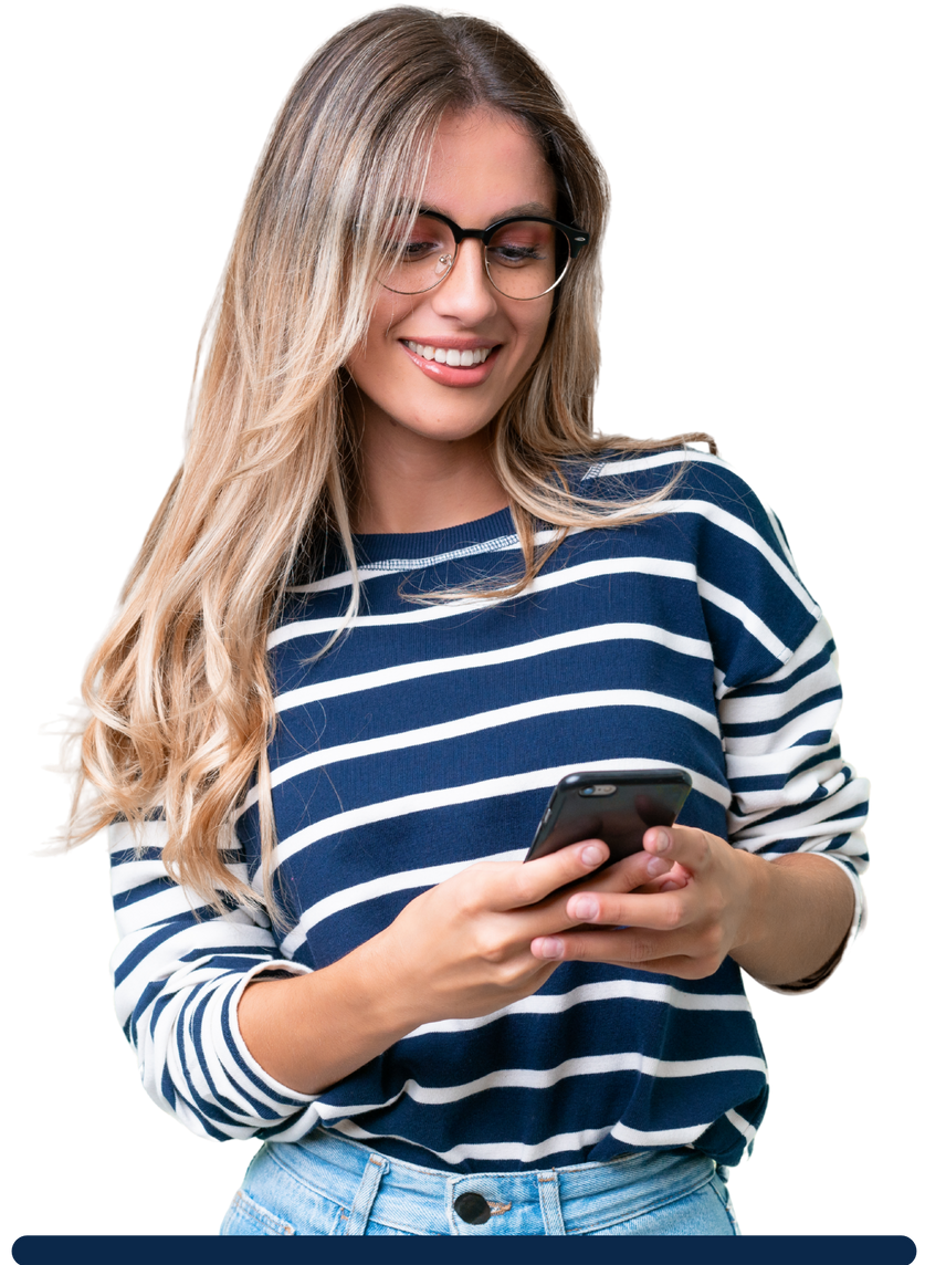 Une femme à lunettes sourit en utilisant son smartphone. Elle porte une chemise à rayures.