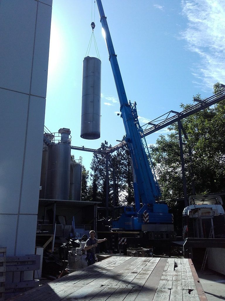 Betonröhre hängt an blauem Kran