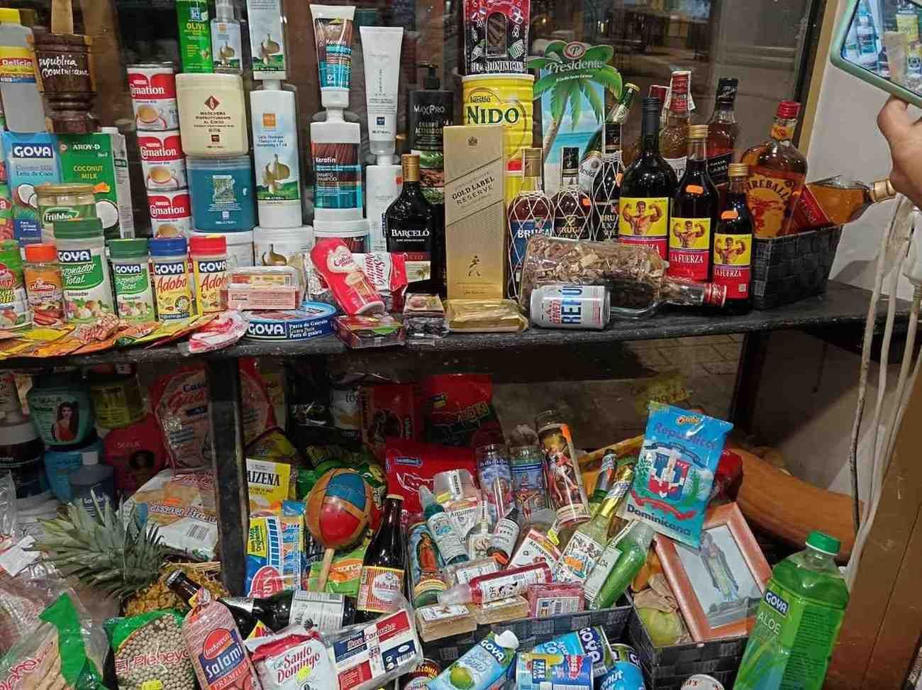 Un estante de una tienda repleto de diversos alimentos y bebidas, incluidas botellas, bocadillos y bebidas.