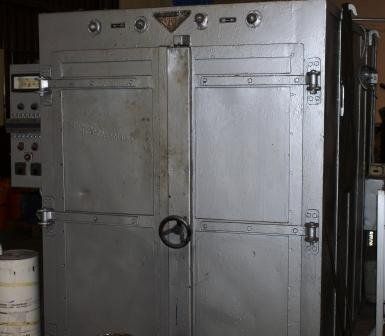 Horno industrial gris de doble puerta con panel de control lateral y manija de cierre central.