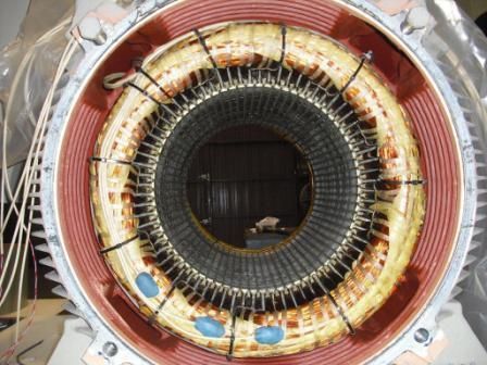 Vista interior del estator de un motor eléctrico, que muestra los devanados de la bobina de cobre dentro de una carcasa metálica.