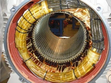 El interior de un motor eléctrico, donde se aprecian los devanados de cobre envueltos en aislamiento amarillo dentro de la carcasa metálica.