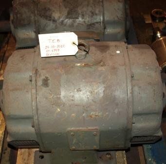 Un gran motor eléctrico industrial de color gris, con una etiqueta de identificación blanca, descansa sobre un palé de madera.