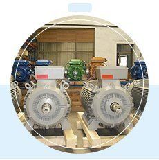 En un almacén, varios motores eléctricos industriales están dispuestos en filas sobre palés de madera.