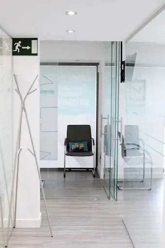 Una sala de espera con una silla y una señal de salida verde.