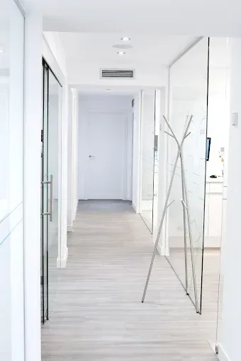 Un pasillo largo con un perchero en el medio.