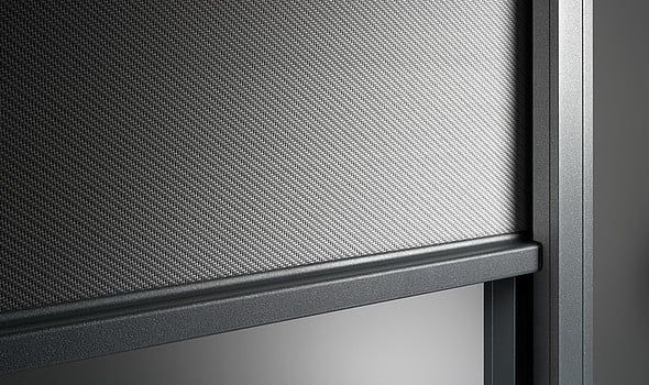 Nahaufnahme eines dunkelgrauen, gewebten Netzschirms in einem grauen Rahmen.