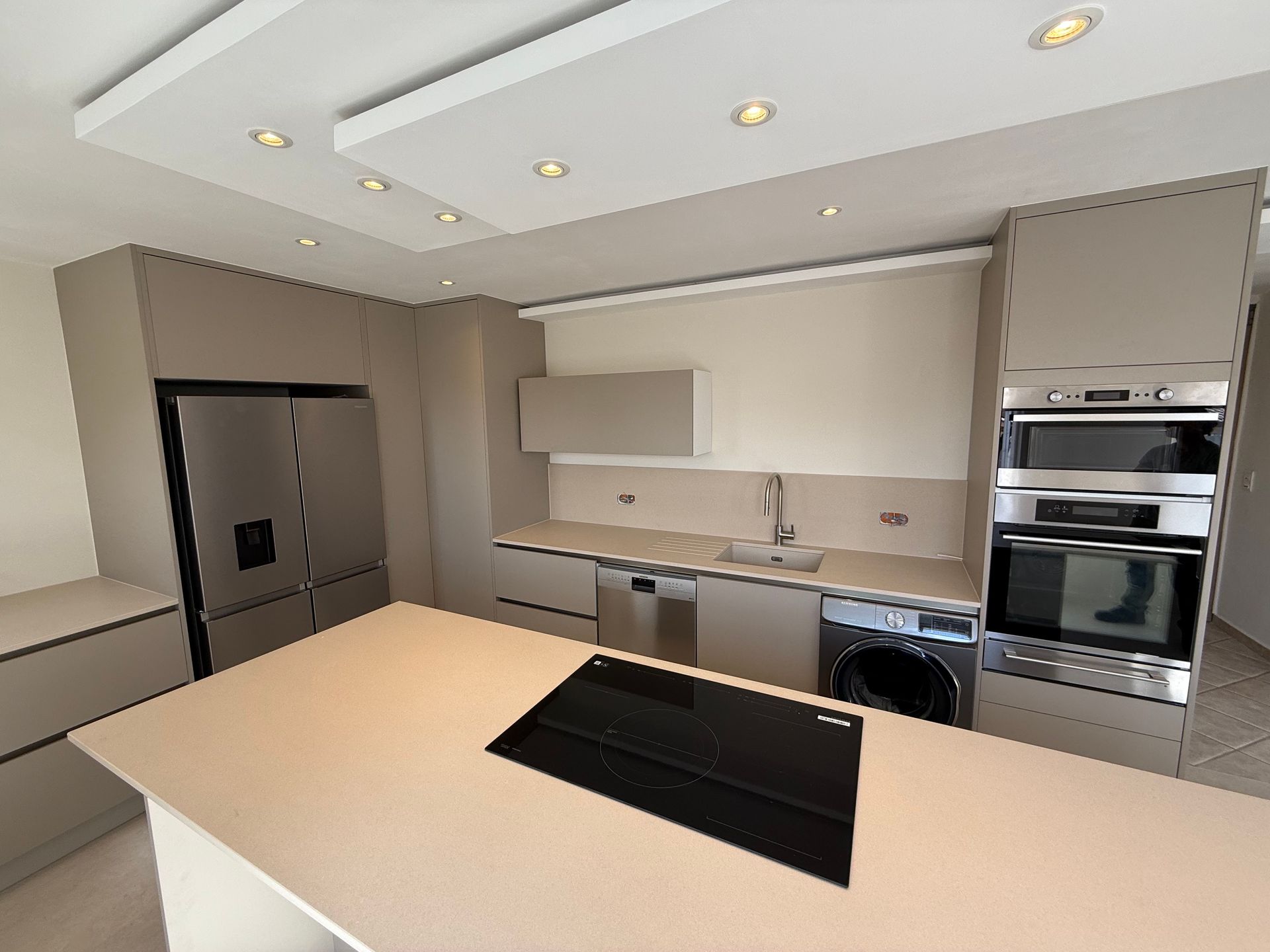Cuisine blanche avec plan de travail en bois et un îlot central
