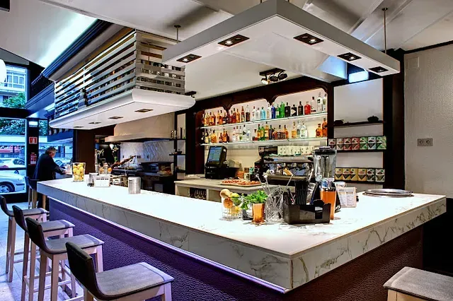 Un bar con muchas botellas en los estantes.