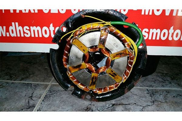 Un motor roto reposa sobre un suelo de baldosas delante de un cartel que dice dhsmotor