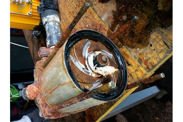 Un trozo de metal oxidado reposa sobre una mesa de madera.