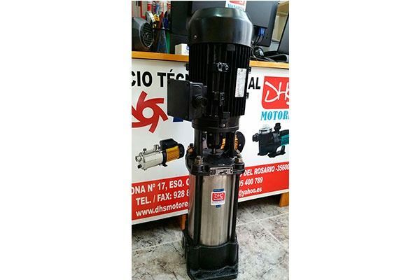 Una bomba de agua de acero inoxidable está situada frente a una tienda.