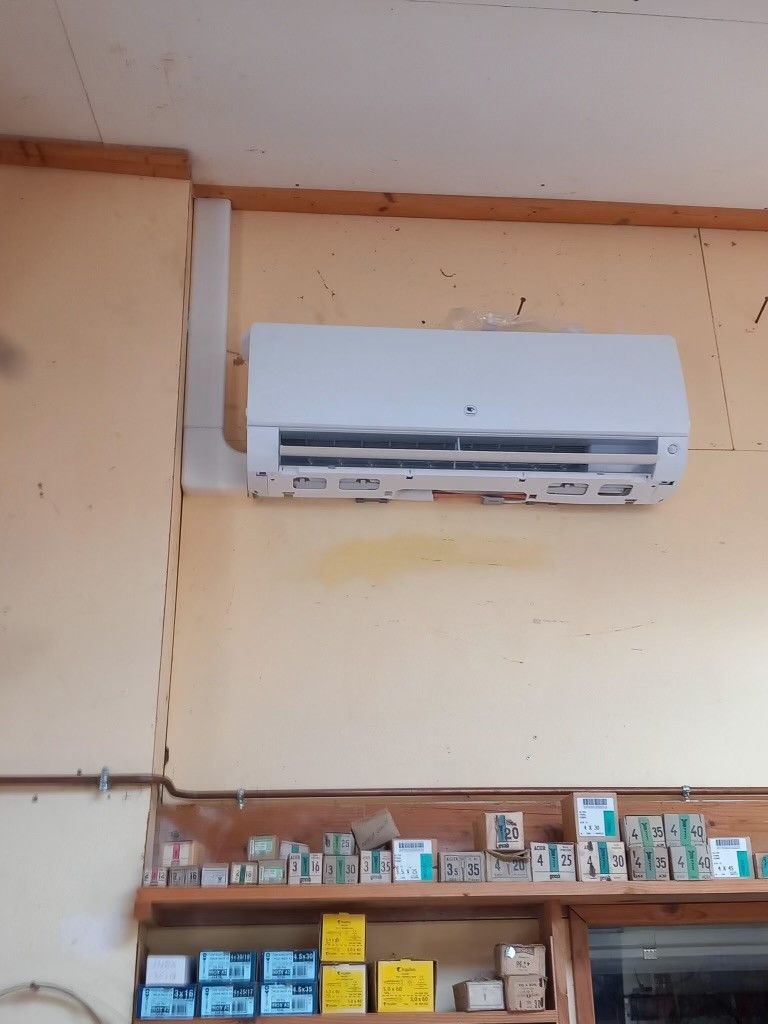 Une unité de climatisation blanche sur un mur de couleur saumon
