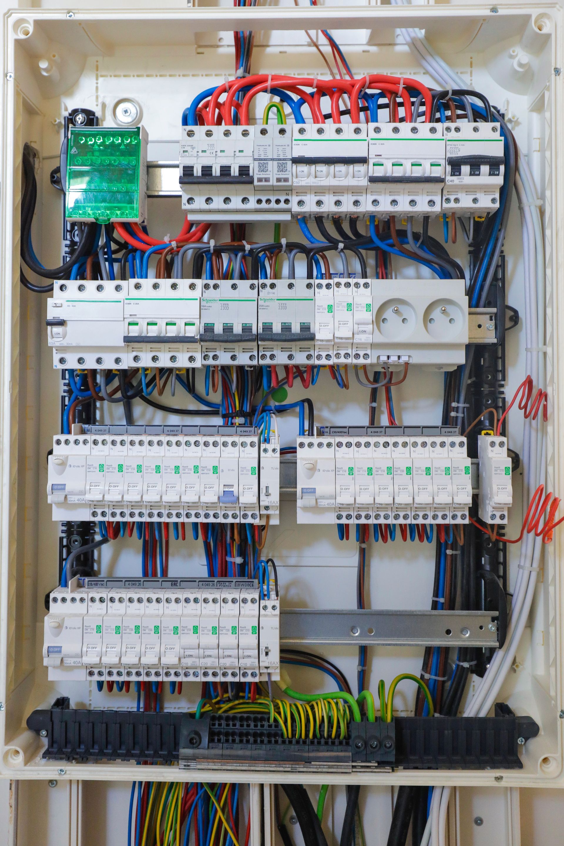 Panneau de commande électrique ouvert avec fils, disjoncteurs et relais disposés en rangées