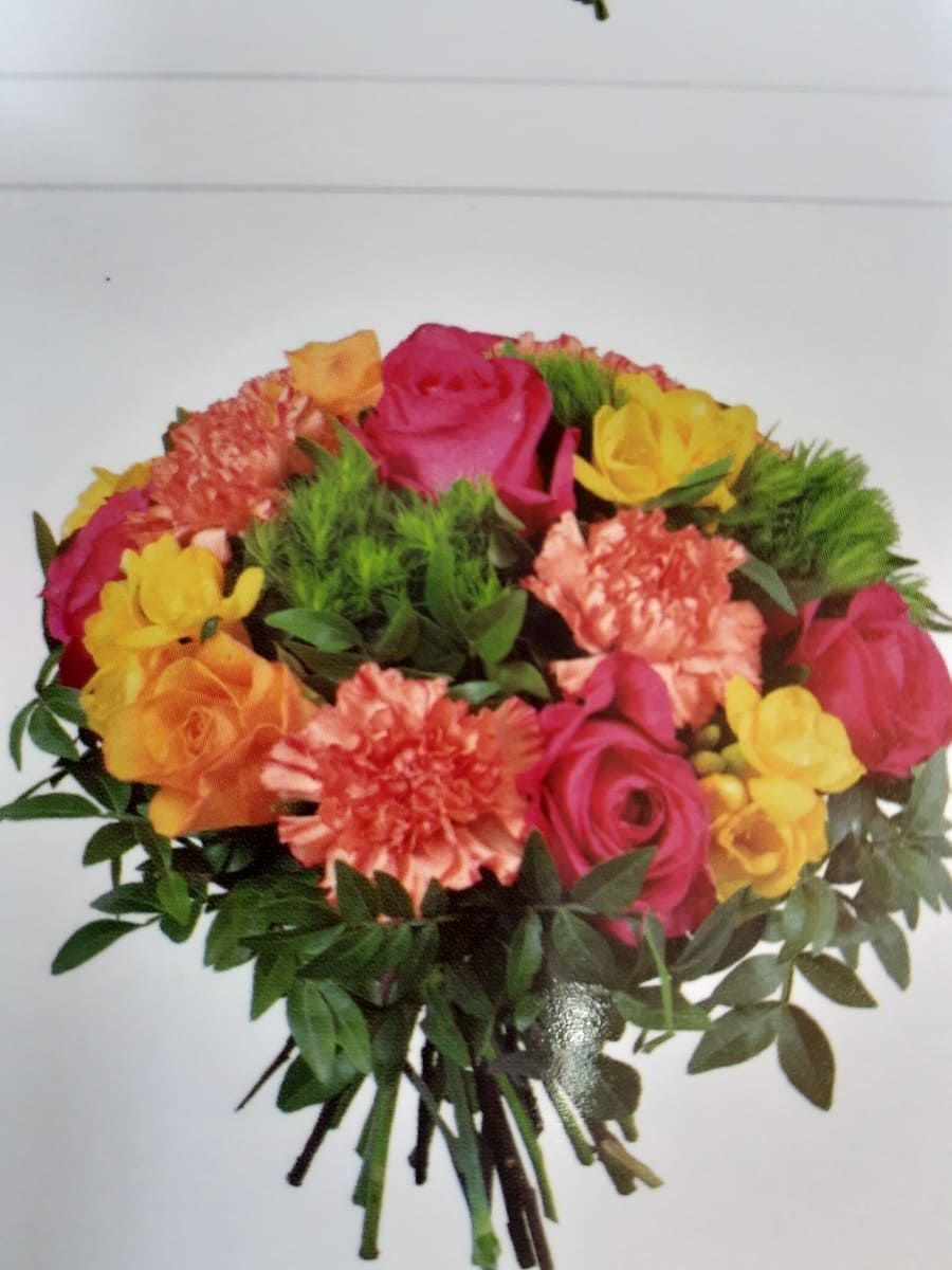 Un ramo de flores de colores que incluye rosas y claveles.