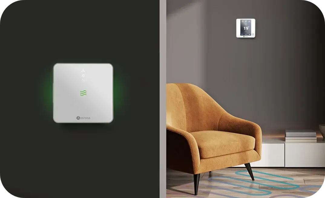 Un appareil carré blanc avec une lumière verte, placé à côté d'un salon avec un fauteuil et une commande murale.