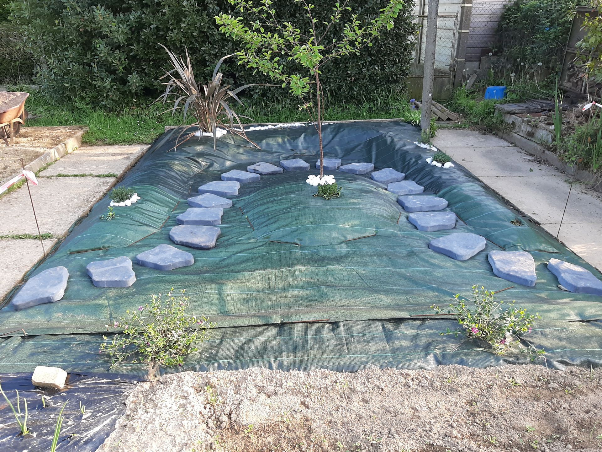 Aménagement d'un jardin avec une bâche et des pierres