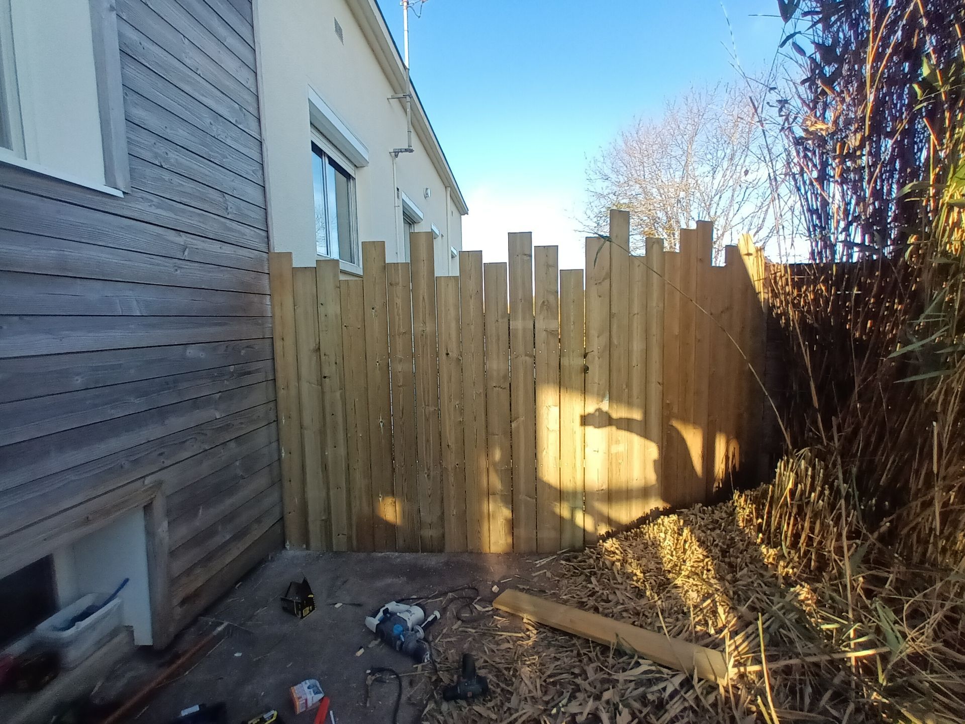 Palissade en bois qui sépare deux jardins