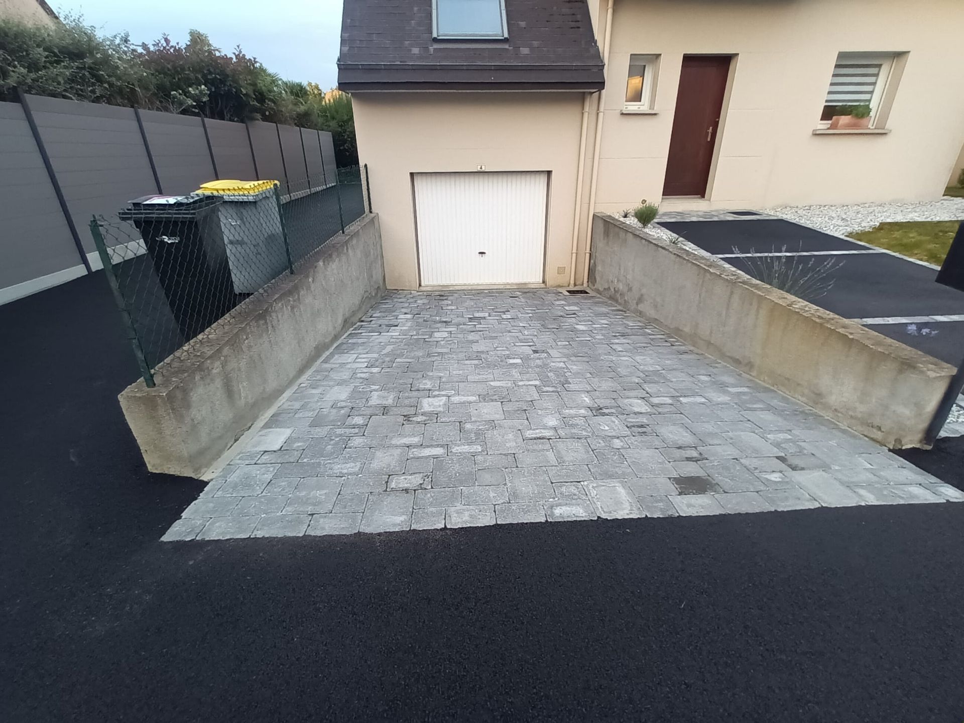 Large allée en pavés devant un garage