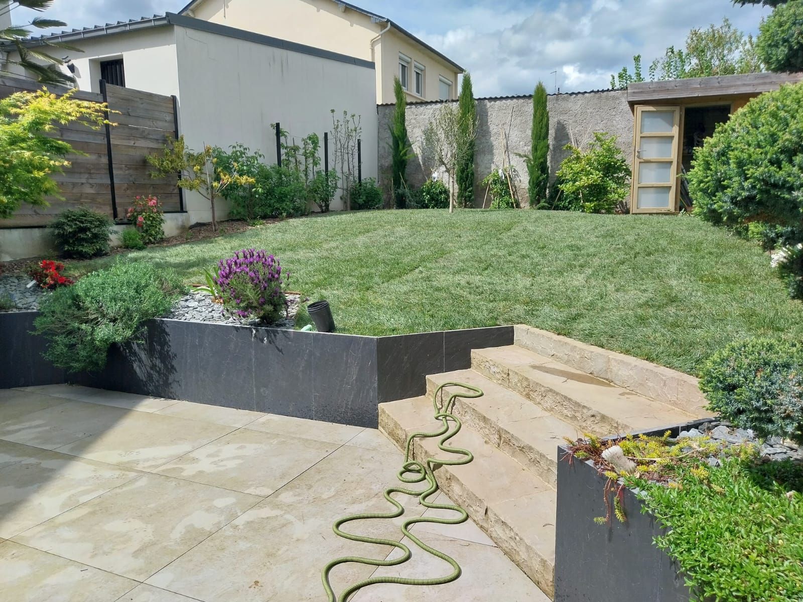 Jardin d'une maison avec une terrasse et un jardin en hauteur