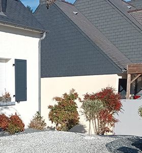 Fenêtre, façade de maison, buissons et graviers