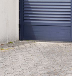 En bas, côté gauche d'un portail battant