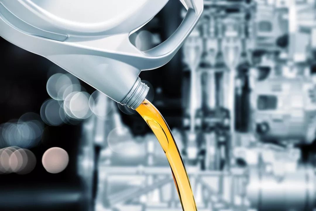 Se vierte una botella de aceite en el motor de un automóvil.